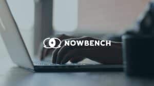 Hands typing on a laptop with the Nowbench logo overlaid in the center.