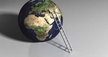 A ladder leaning against a 3D Earth model on a gray background, symbolizing reaching for global goals.