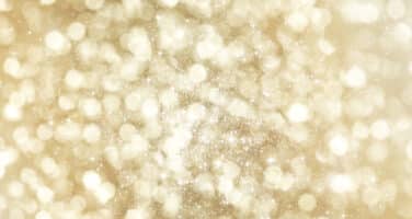 A shimmering, abstract background featuring a multitude of soft, glowing golden bokeh lights.