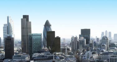 Skyline of a modern city featuring distinctive skyscrapers and a clear blue sky.
