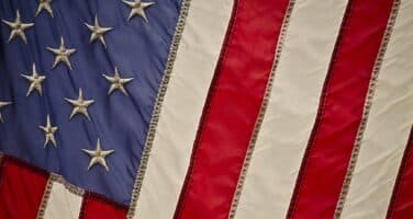 Close-up of an American flag, showing the star-spangled blue section alongside red and white stripes.