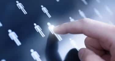 A finger touching a digital screen displaying multiple small human icons, highlighting one icon.