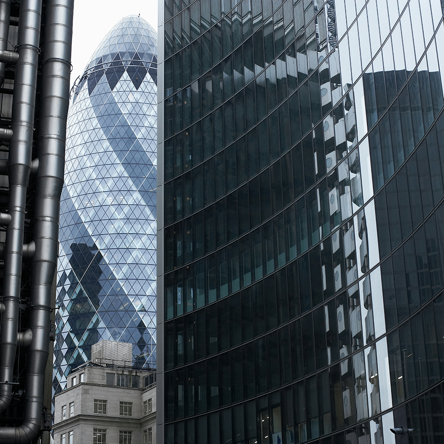Skyscrapers in a cityscape with the distinctive Gherkin building featuring a glass and steel structure, surrounded by modern high-rise buildings.