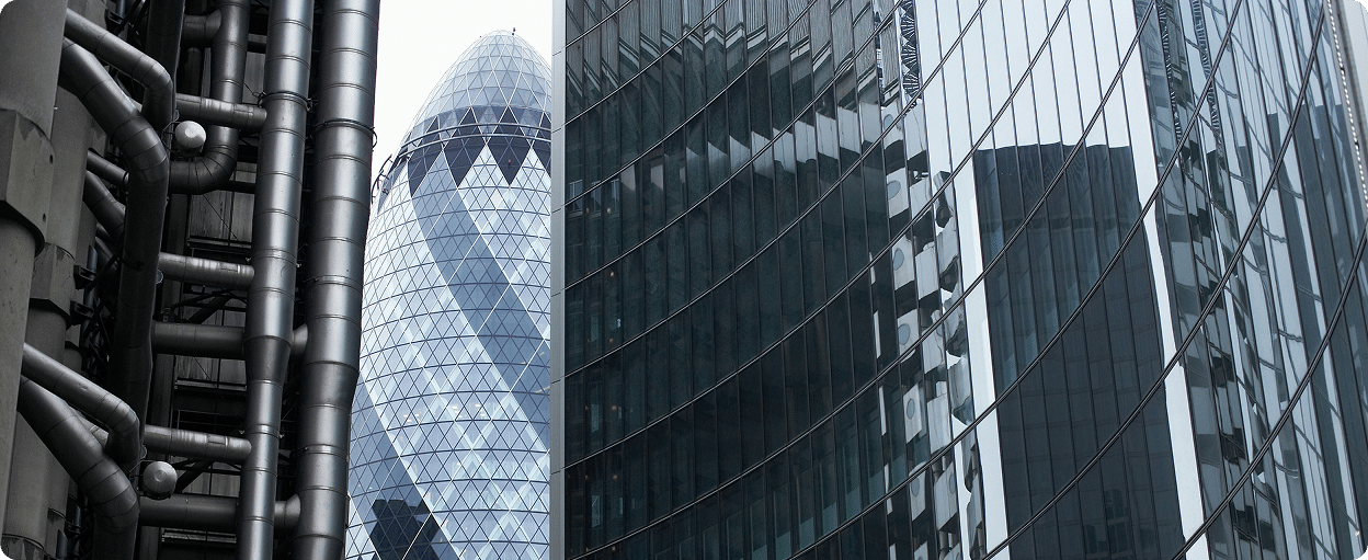 Tall modern skyscrapers with reflective glass exteriors dominate the cityscape, including a distinctive conical building with a diamond-patterned facade.